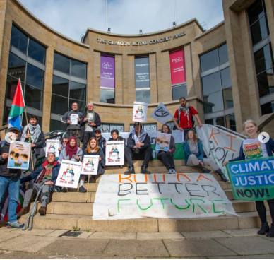A photo of a group of people sitting on concrete steps. A banner reads "Build a better future".