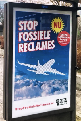 A photo of a framed poster displayed in a bus stop shelter. The words "stop fossiele reclames" are featured prominent. There is an XR logo near the bottom.